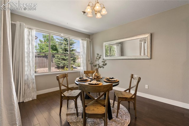 dining room featuring dark wood-type flooring and an inviting chandelier