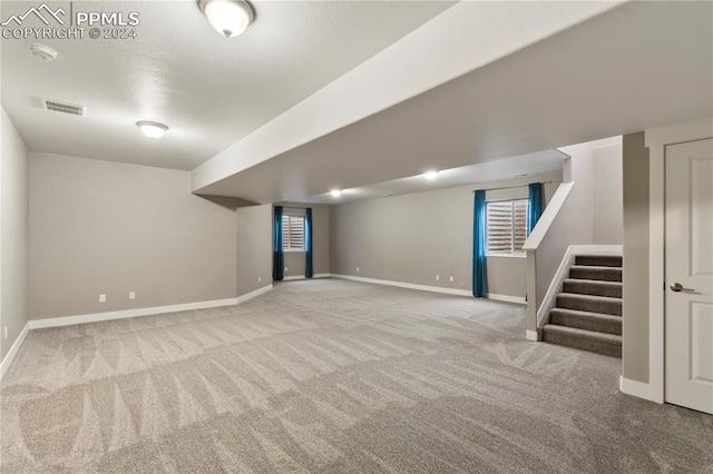 basement with light carpet and a healthy amount of sunlight