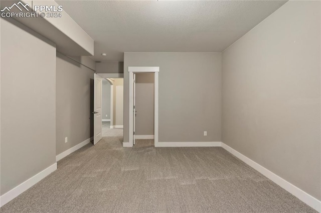 unfurnished bedroom featuring a textured ceiling and light carpet