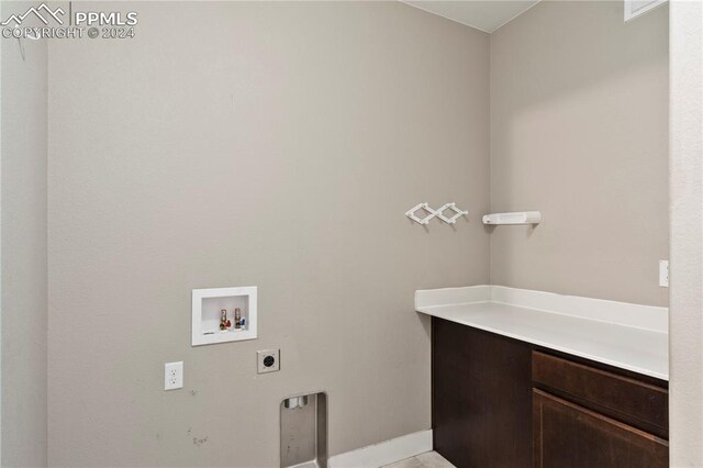 clothes washing area featuring washer hookup, electric dryer hookup, and cabinets