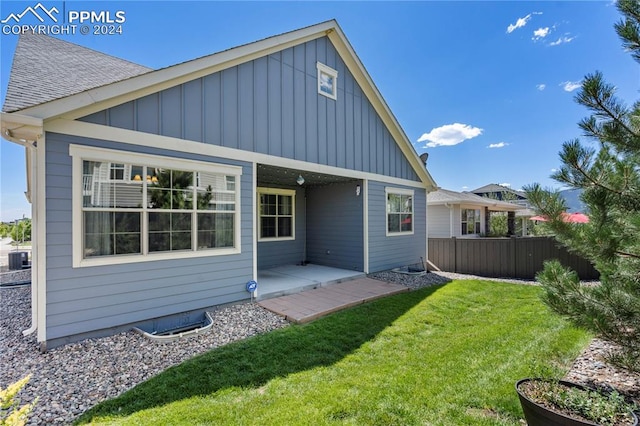 rear view of house featuring a yard and central AC unit