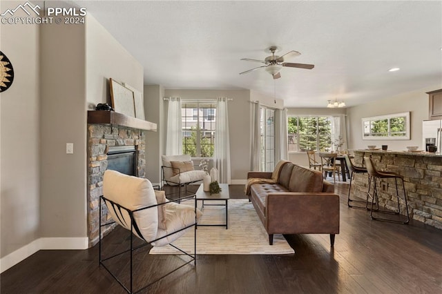 living room with a fireplace, ceiling fan, and wood-type flooring