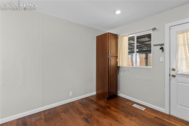 unfurnished room with dark wood-type flooring