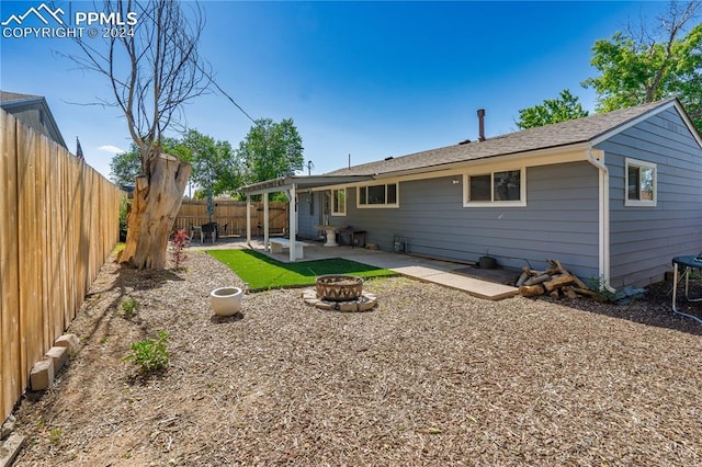 rear view of house featuring a fire pit and a patio area