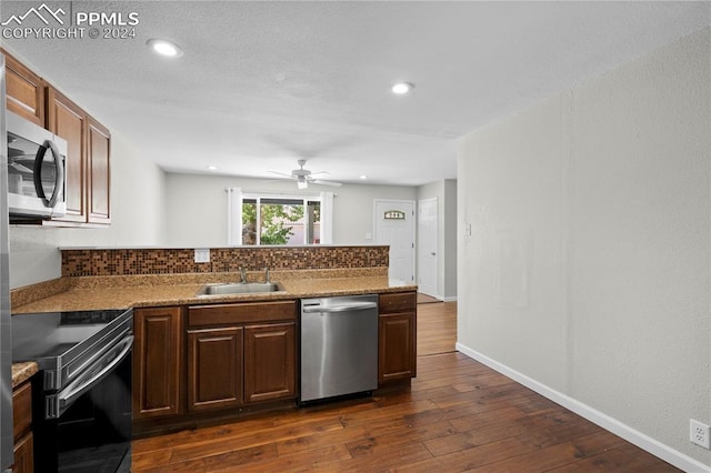 kitchen featuring sink, backsplash, ceiling fan, appliances with stainless steel finishes, and dark hardwood / wood-style floors