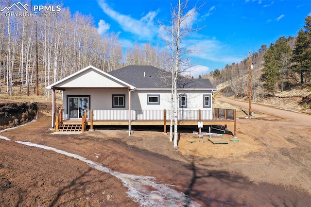 back of property featuring a deck and covered porch