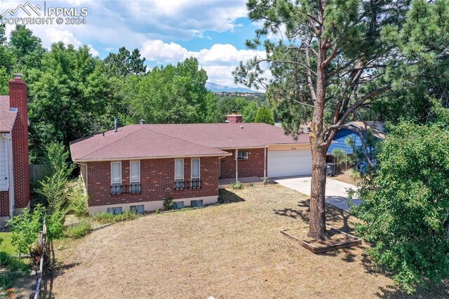 ranch-style home with a garage and a front lawn