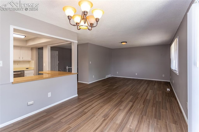 interior space featuring dark hardwood / wood-style flooring, an inviting chandelier, and a textured ceiling