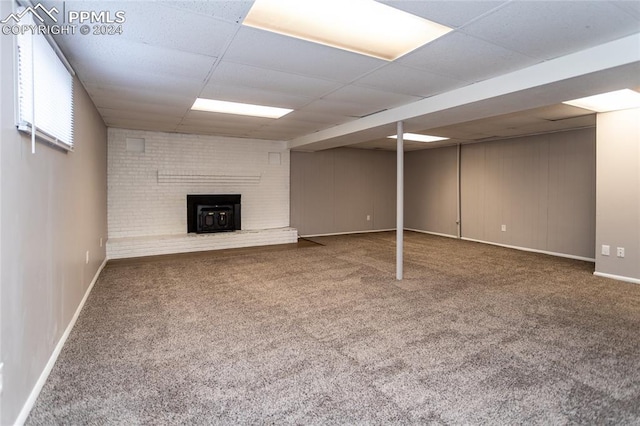 basement with a paneled ceiling and carpet