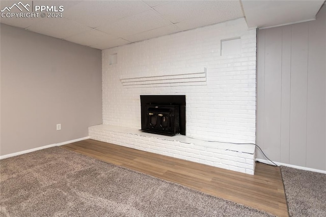 unfurnished living room featuring a brick fireplace and wood-type flooring