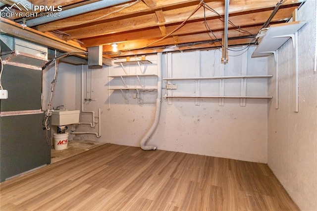 basement featuring sink and hardwood / wood-style flooring