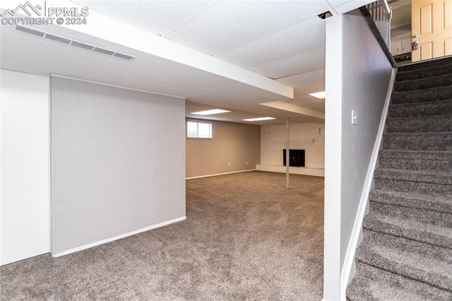 basement featuring a fireplace and carpet flooring