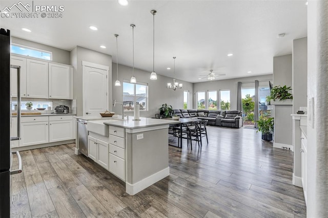 kitchen with hardwood / wood-style flooring, white cabinets, and a center island with sink