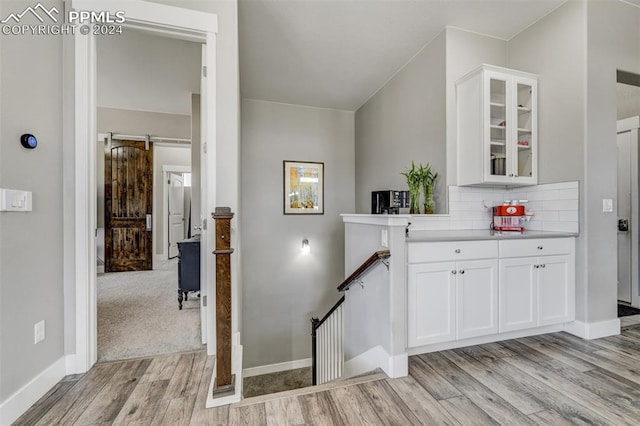 stairway with light colored carpet and a barn door