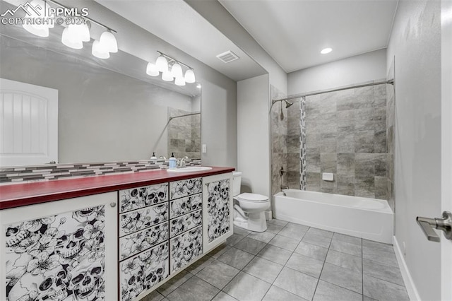 full bathroom featuring tiled shower / bath combo, tile patterned floors, toilet, and vanity