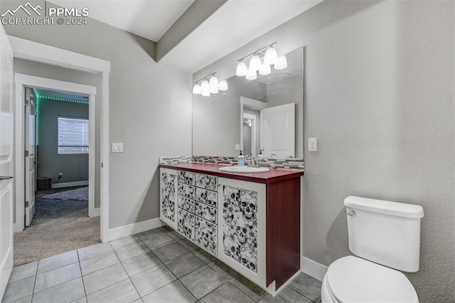 bathroom featuring vanity, tile patterned flooring, and toilet