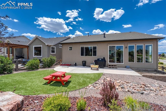 rear view of property with a pergola, a yard, and a patio area