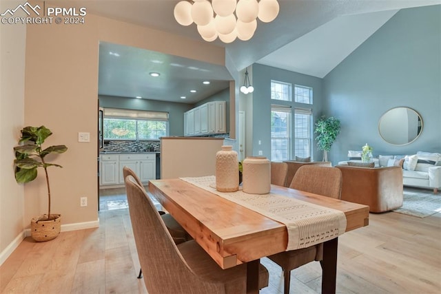 dining area featuring a wealth of natural light, light hardwood / wood-style floors, a chandelier, and vaulted ceiling