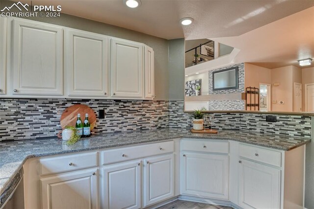 kitchen with decorative backsplash, stainless steel dishwasher, white cabinets, and stone counters