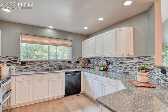 kitchen featuring light stone counters, sink, and black dishwasher