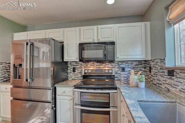 kitchen featuring appliances with stainless steel finishes, light stone countertops, and white cabinets