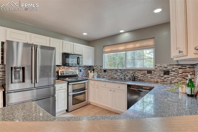 kitchen with tasteful backsplash, sink, white cabinets, dark stone counters, and black appliances