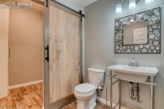 bathroom with hardwood / wood-style flooring and toilet