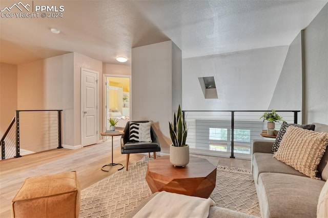 living room featuring a textured ceiling and light hardwood / wood-style floors