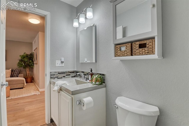 bathroom with vanity, hardwood / wood-style flooring, and toilet