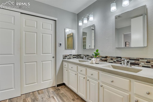 bathroom featuring wood-type flooring, vanity, and backsplash