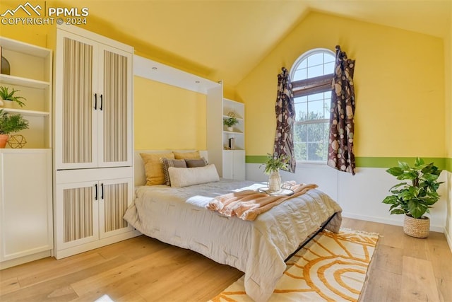 bedroom featuring lofted ceiling and light hardwood / wood-style flooring