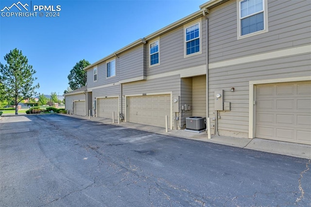 exterior space with a garage and central air condition unit