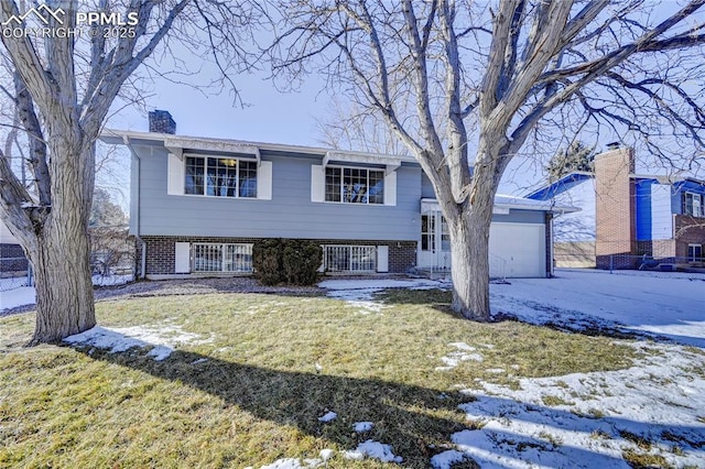 bi-level home featuring a garage and a yard