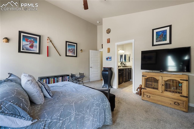 carpeted bedroom with ensuite bath and ceiling fan