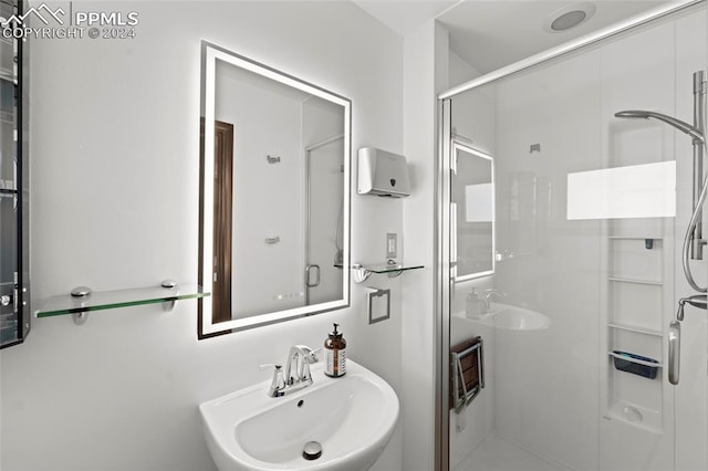 bathroom featuring sink and a shower with door