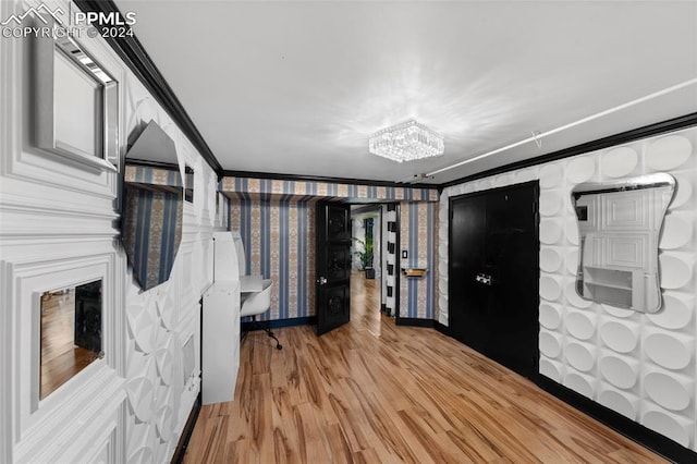 interior space featuring crown molding, light hardwood / wood-style flooring, and an inviting chandelier