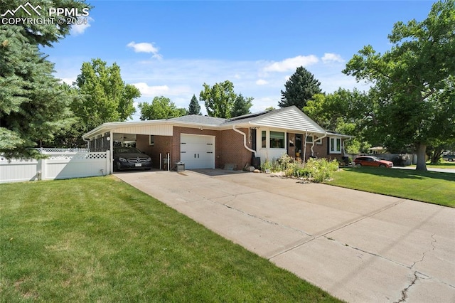 ranch-style house featuring a carport, a garage, and a front yard