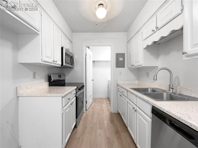 kitchen featuring sink, white cabinets, electric panel, stainless steel appliances, and light wood-type flooring