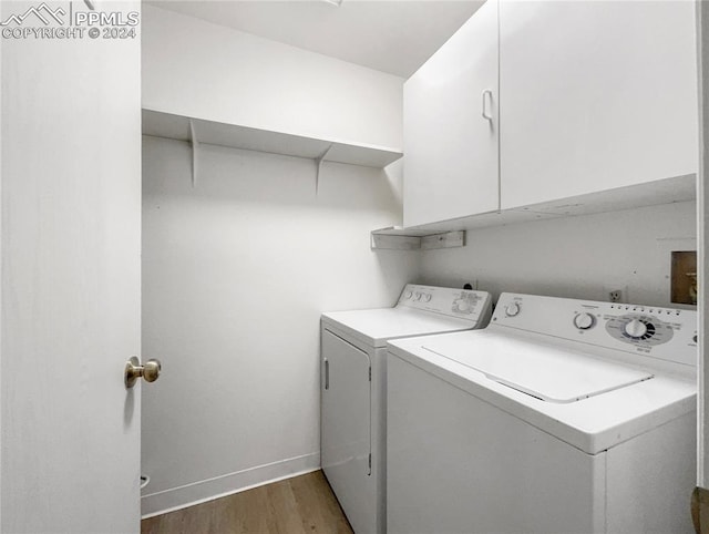 laundry room with cabinets, separate washer and dryer, and dark wood-type flooring