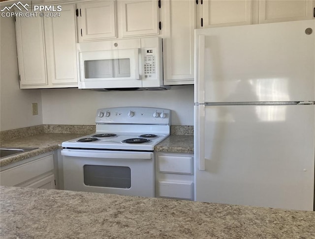 kitchen with white appliances and white cabinets