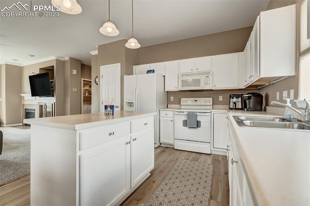 kitchen with pendant lighting, sink, white cabinets, a center island, and white appliances