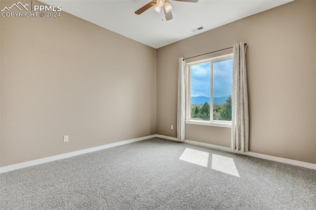 carpeted spare room featuring ceiling fan