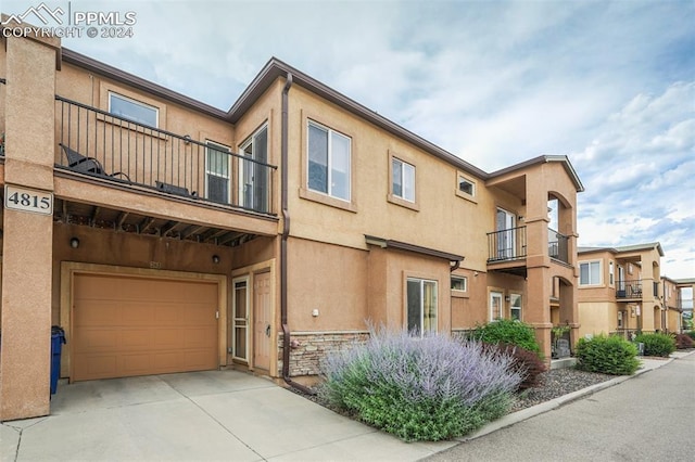 view of front of home featuring a garage and a balcony