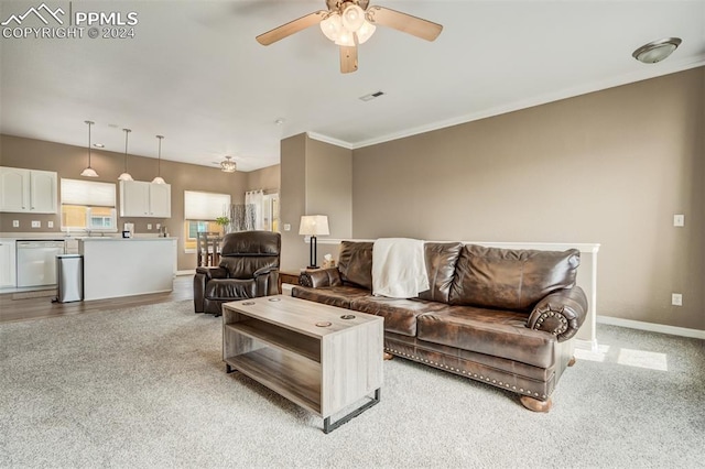 living room featuring ornamental molding, light colored carpet, and ceiling fan