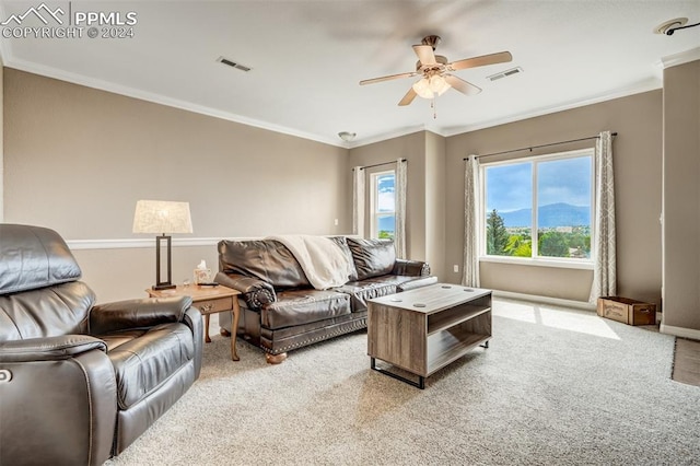 carpeted living room with ornamental molding and ceiling fan