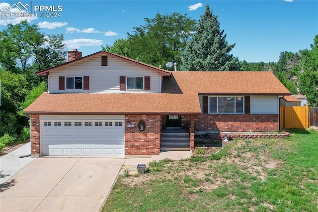 tri-level home featuring a garage and a front yard