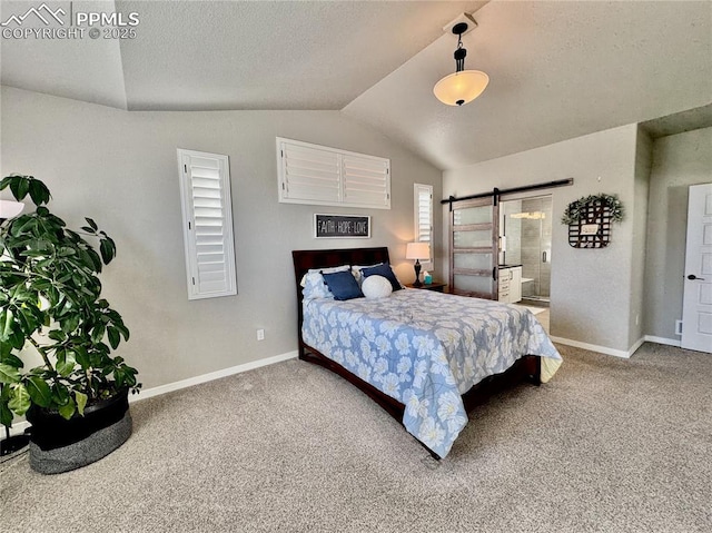 carpeted bedroom featuring connected bathroom, vaulted ceiling, a barn door, and a textured ceiling