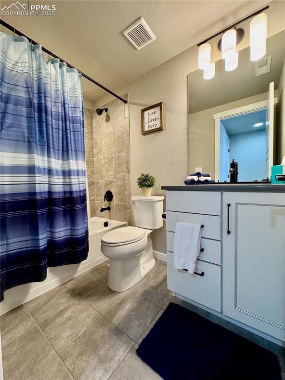 full bathroom with vanity, shower / bath combo, a textured ceiling, and toilet