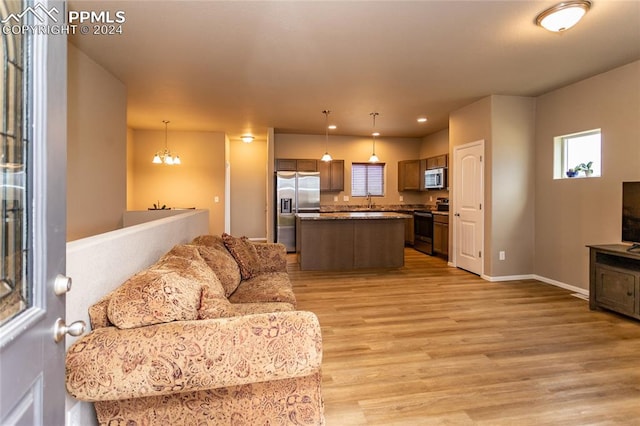 living room with a chandelier, light hardwood / wood-style floors, and sink