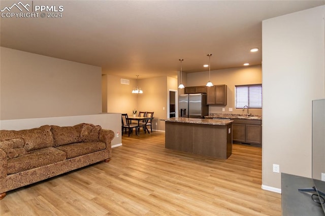 living room featuring sink, an inviting chandelier, and light hardwood / wood-style floors